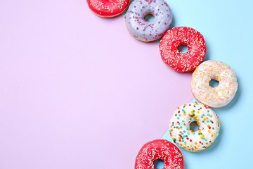 Sweet tasty donuts on color background