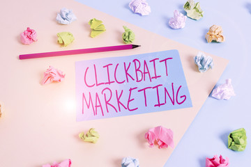 Writing note showing Clickbait Marketing. Business concept for Online content that aim to generate page views Colored crumpled papers empty reminder blue yellow clothespin