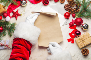 Santa Claus with empty paper sheet on white table