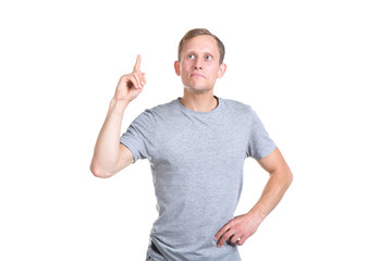 Young man points a finger up, standing on a white background.