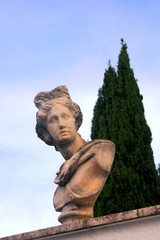 Fototapeta premium Classic style bust in front of a row of cypresses, in Terracina, Italy.