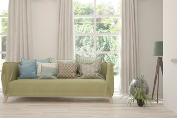 Stylish room in white color with sofa and summer landscape in window. Scandinavian interior design. 3D illustration