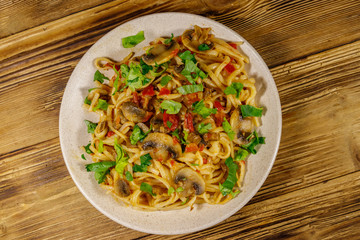 Pasta with mushrooms and tomato sauce on wooden table. Top view