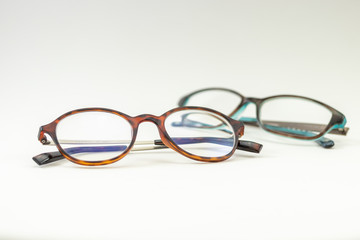Two pairs of modern glasses isolated in a studio shot one with black and turquoise colored frames...