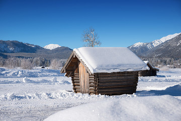 Holzhütte im verschneiten Tal bei Garmisch, Blick auf die Waxensteine, Wettersteingebirge im Winter