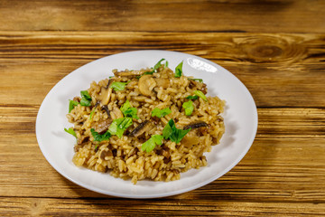 Tasty risotto with mushrooms on wooden table