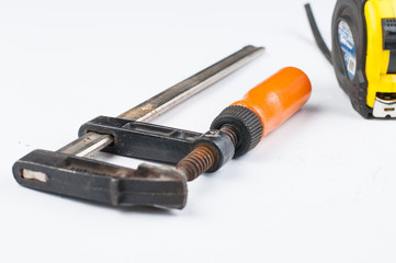 Carpentry clamp and measuring meter isolated on white background