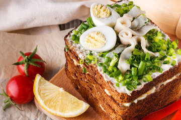 a huge herring sandwich with mayonnaise and quail eggs