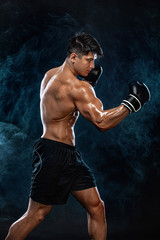 Fitness and boxing concept. Boxer, man fighting or posing in gloves on black background. Individual sports recreation.