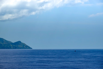 The hazy and mountainous coastline of the Caribbean Island of Haiti as a cruise ship sails by.