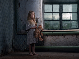 A little girl in a terribly dirty beggar's house