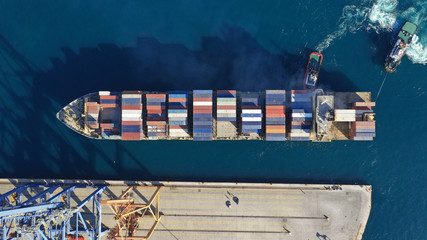 Aerial drone top down photo of industrial cargo container tanker ship carrier docked in commercial...