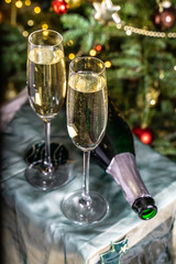 A bottle of champagne and two filled glasses on New Year's Eve