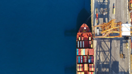 Aerial drone top down photo of industrial cargo container tanker ship carrier docked in commercial port terminal - obrazy, fototapety, plakaty