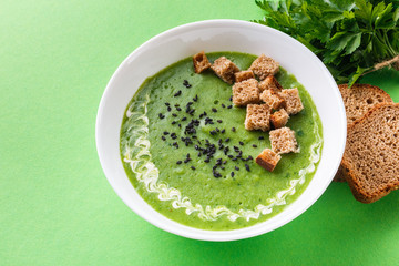 broccoli spinach cream soup on green paper background