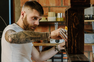 Wood designer working and painting a wooden product in his workshop