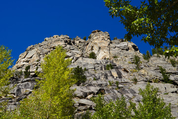 The immense and beautiful granite walls of the Tetons canyons are stunning against a brilliant blue sky.
