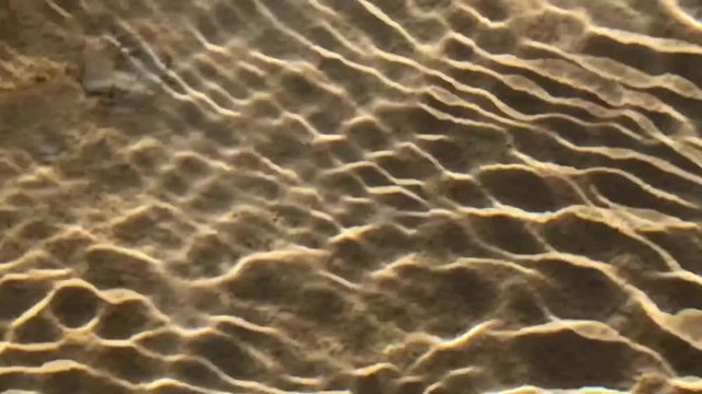 Sunlight shining through ripples of water creating interesting patterns