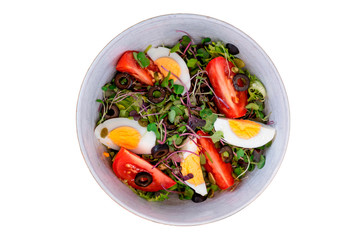 Healthy vegetable salad with mixed green leaves (arugula, mesclun, lettuce), eggs, black olives, tomato and bean sprouts. white background. Top view