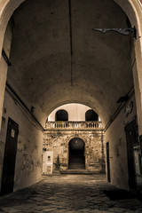 Obraz premium vecchio cortile con archi e scale