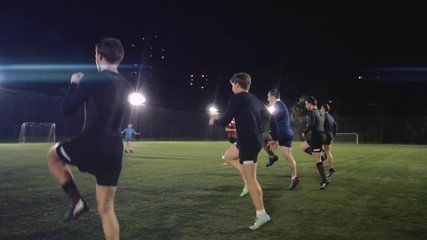 Soccer football players during the team training before the match. Exercises for football soccer youth team. Young player exercises with ball and marker cones, running training rugby men athlete - Powered by Adobe