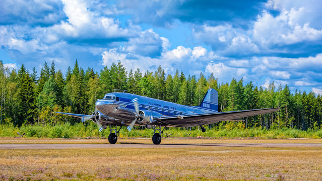 Short-haul transport aircraft with two piston engines Douglas DC-3A-447 OH-LCH Airveteran in Finnish Airlines livery take off from Karhula aviation museum airshow. Kotka, Finland.