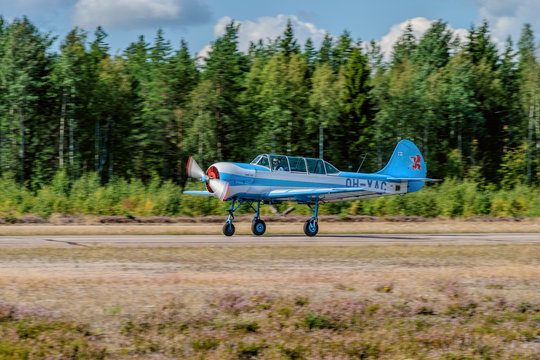 Two-seat single-engined piston-powered Yakovlev Yak-52 primary aerobatic trainer aircraft OH-YAC landing on Karhula aviation museum airshow. Kotka, Finland.