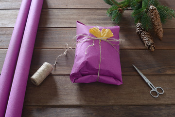 man's packing Christmas gift over wooden table