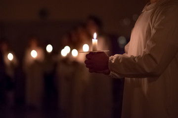 Boys are handling candles in the traditionall religious habit dresses in the church. Celebration of Lucia day in Sweden