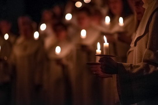 People are handling candles in the traditionall religious habit dresses in the church. Celebration of Lucia day, Sweden