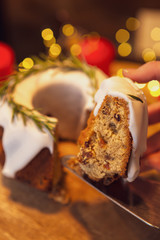 decorated Christmas cake - Traditional European Christmas pastry, fragrant home baked stollen, Sliced on wooden table with xmas tree branches and decorations