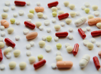 Pharmacology assorted medicine pills, tablets and capsules background pattern texture. Different colors tablet on white background. Health care. Top view with Copy space