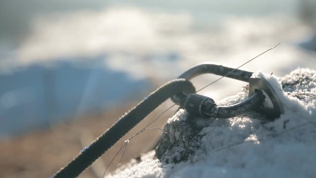 Climbing rope slides in a carabiner. Insurance climbers closeup.