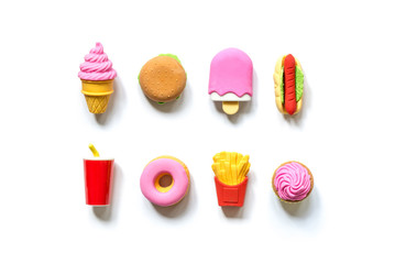 A variety of toy fast food and different sweets in miniature with shadows isolated on a white background.