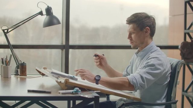 Concept architects,engineer holding pen pointing equipment architects On the desk with a blueprint in the office, Vintage, Sunset light. Close Up Of A Draftsman Drawing Diagram On Blueprints.