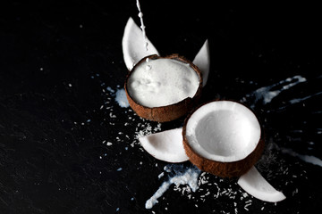 fresh coconut milk is poured into a broken empty coconut, the process of preparing the product, an exotic cocktail