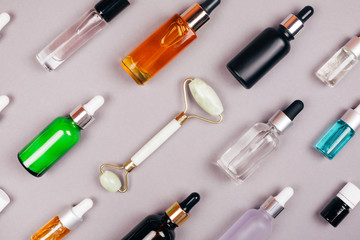 Group of oils and serums for self-care in different colors. Copy space, flat lay style.