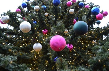 Fototapeta na wymiar Multi-colored balls on a street Christmas tree.