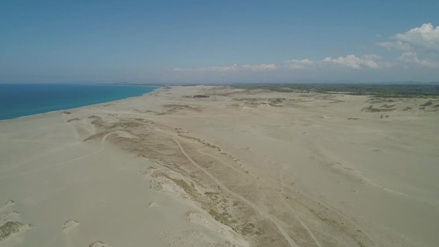 Aerial view beautiful lonely beach and Paoay sand dune. Philippines, Luzon. Sand dunes near to the sea with sky. Ilocos Norte.