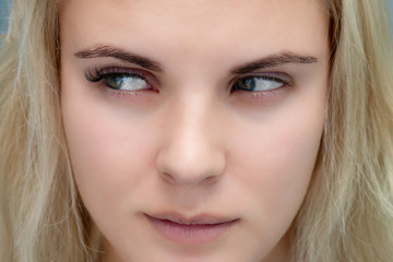 Fototapeta premium Eyelash extensions, natural volume, beautiful woman looking away to show the difference before and after procedure