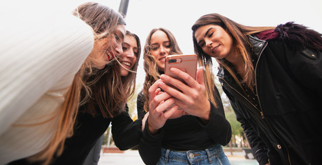 four friends watching an interested mobile phone