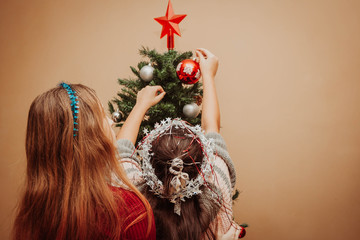 Two girls decorating the Christmas tree