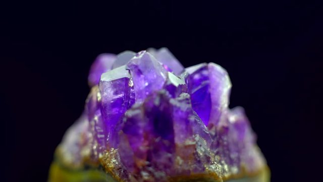 Natural amethyst rotation 360 over black background. 4k. Macro shot.