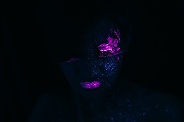 Portrait of Beautiful Fashion Woman in Neon UF Light. Model Girl with Fluorescent Creative Psychedelic MakeUp, Art Design of Female Model in UV