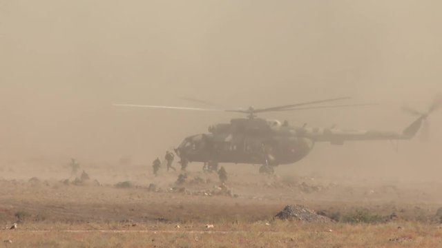Military soldiers jump out of the helicopter