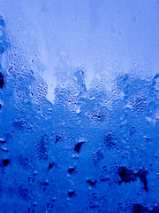 Textured blue background with raindrops. Cold and wet concept.