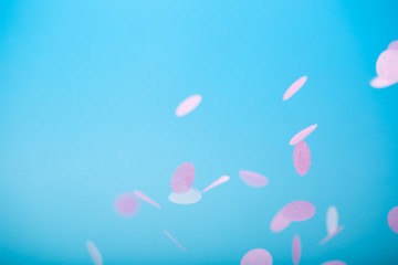 Orange and yellow falling confetti on blue background