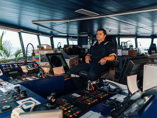 Fototapeta na wymiar Marine navigational officer during navigational watch on Bridge . Work at sea