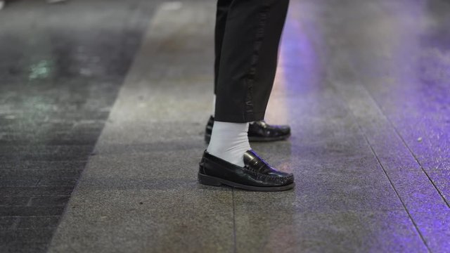 Close-up feet dancing with white socks and black shoe