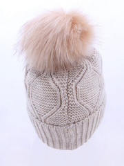 Beige Wool Knit Ski Hat with Faux Fur Pompom Isolated on White. Bobble Hat Topped with Pom Pom or Loose Tassels. Knit Cap Folded Brim. Knitted Warm Hat. Tuque or Toque Outdoors Headgear